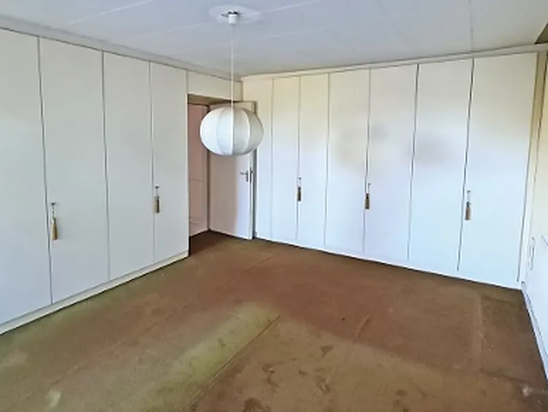 Vorher: Schlafzimmer mit altem Teppich und Einbauschränken