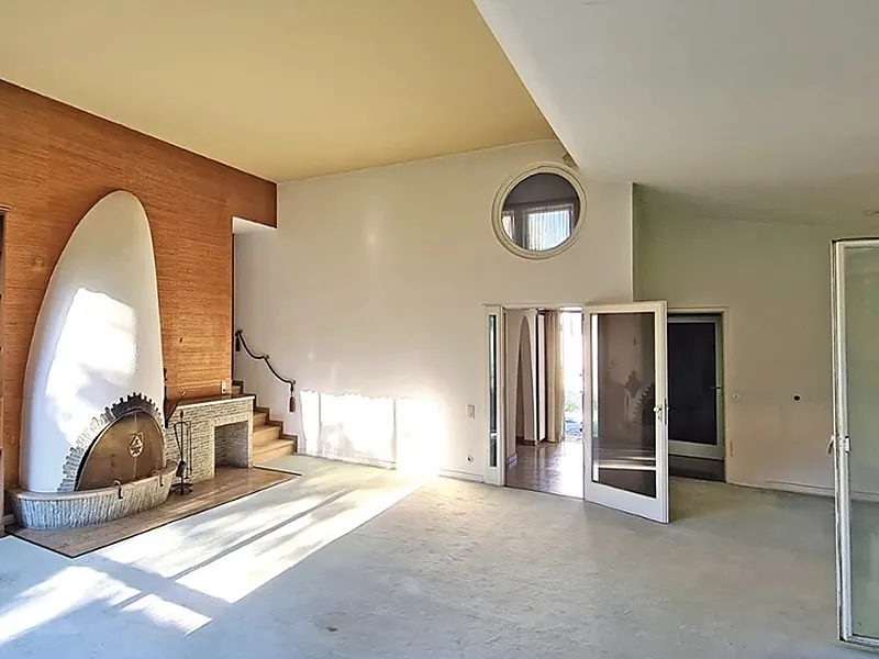 Vorher: Wohnzimmer mit Holzverkleidung und offenem Kamin